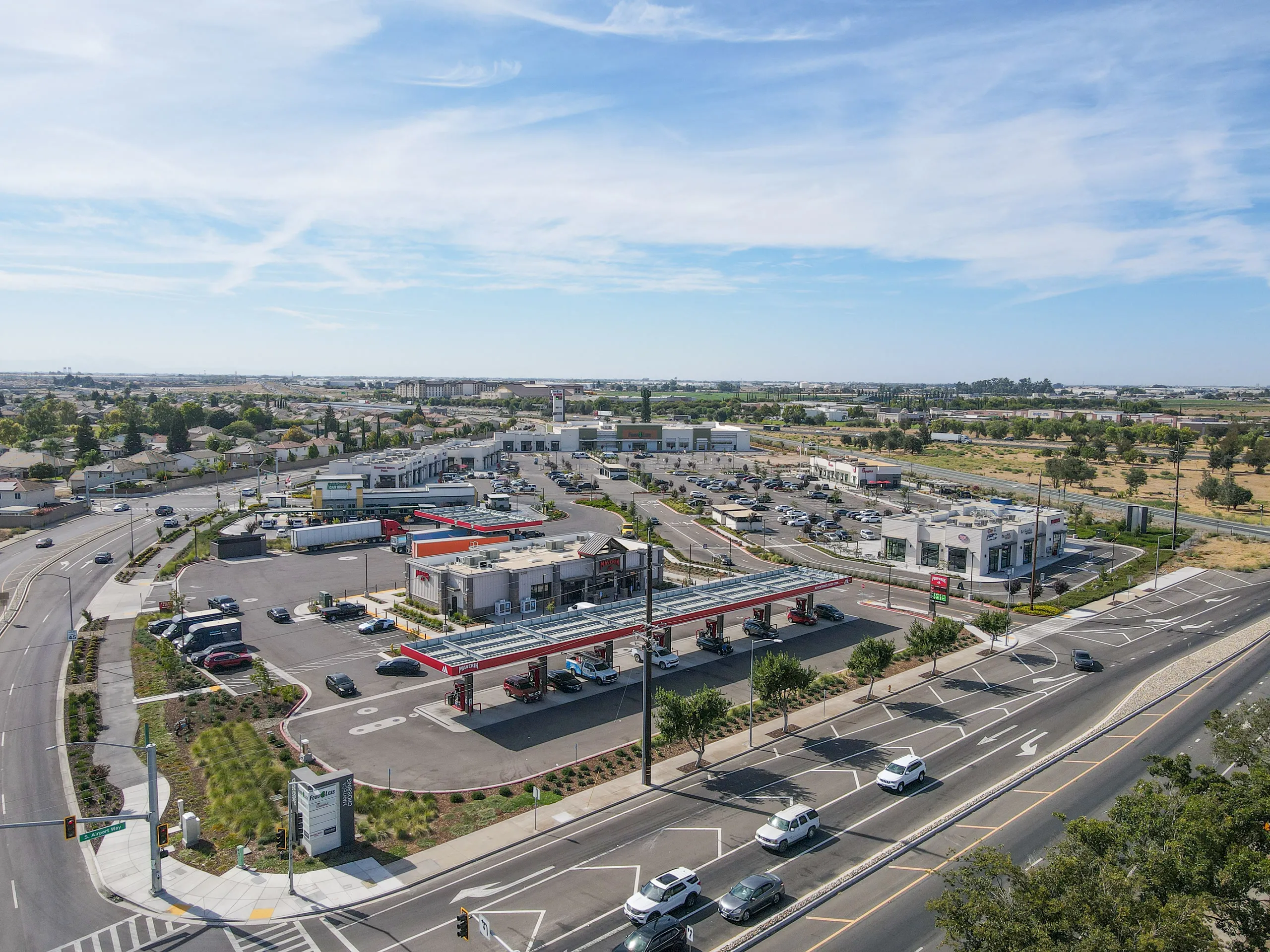 Aerial view of Manteca Crossing from the Airport Way entrance, with the Maverik fuel canopy and Chick-fil-A in front and Food 4 Less beyond