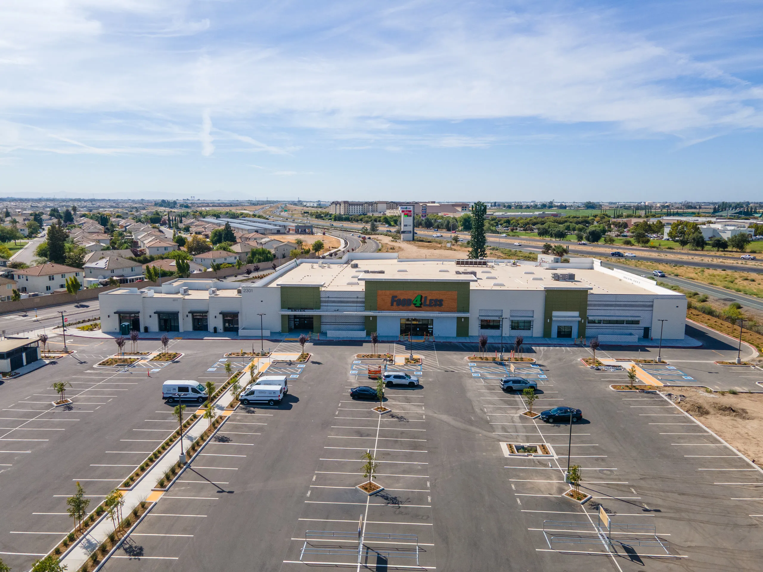 Food 4 Less storefront and the front parking field at Manteca Crossing, August 2026