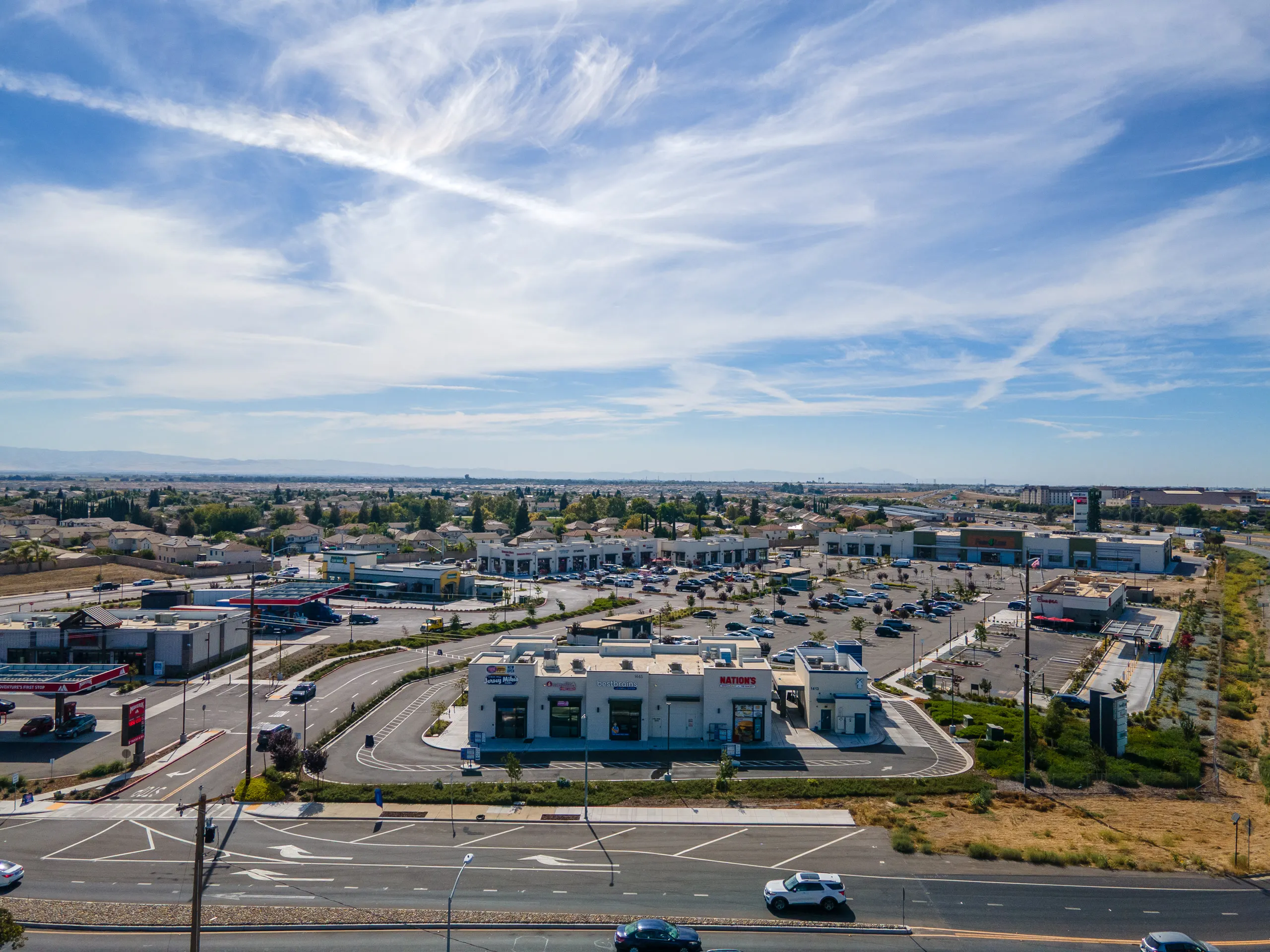 Aerial view of the Shops D building along Airport Way, with the rest of the center behind it
