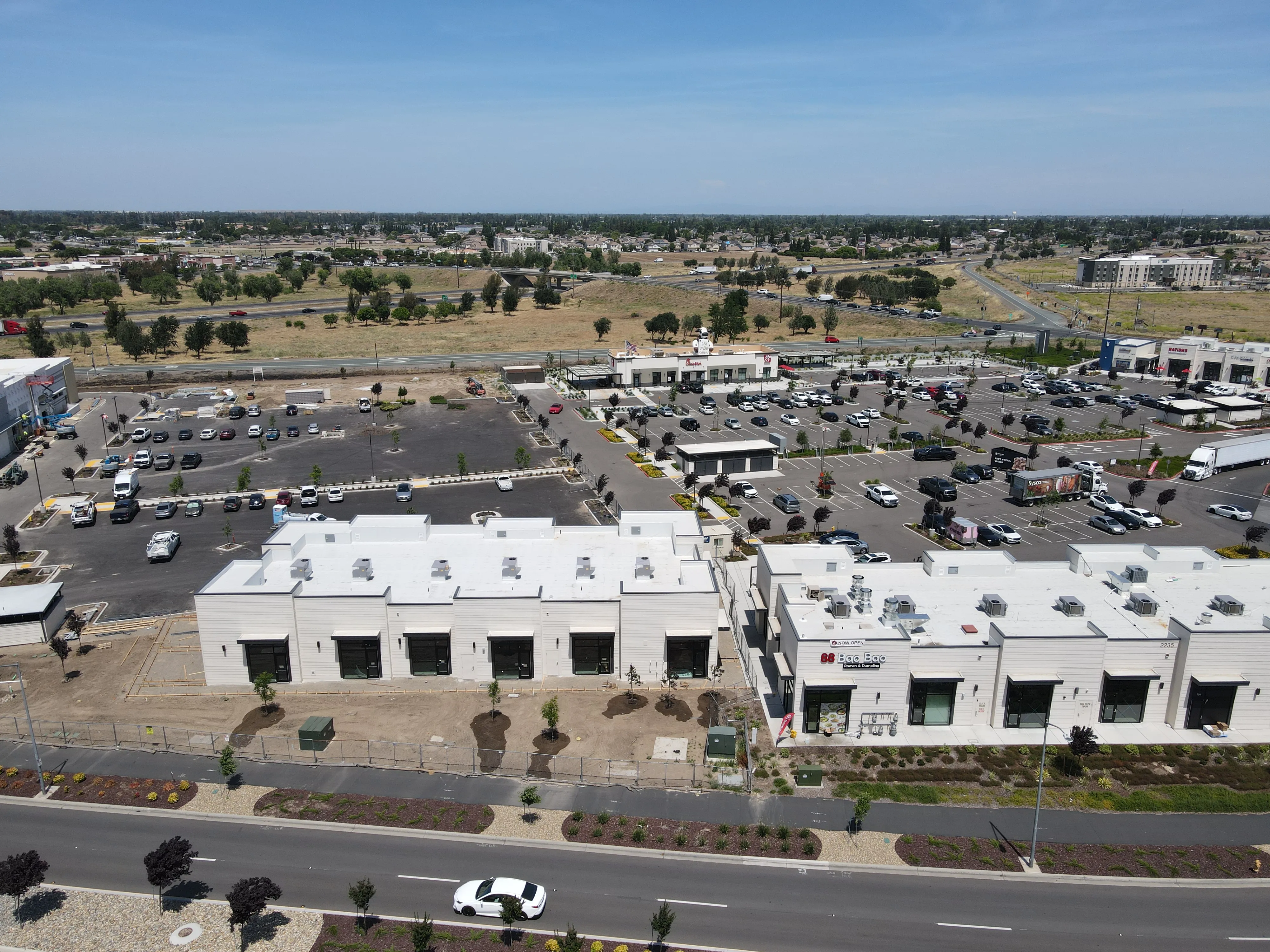 Aerial view of the back of Shops J with the main parking field and shop buildings beyond